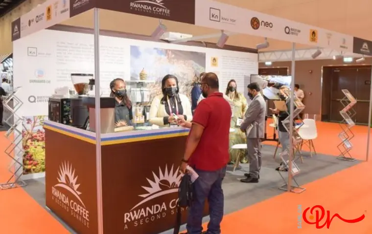 نمایشگاه قهوه اصفهان و آقایی با لباس قرمز در حال گرفتن مشاوره
