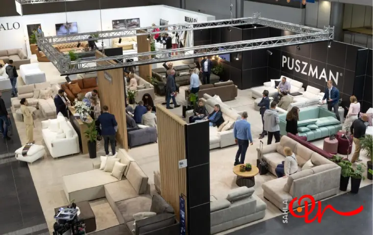 نمای بالای یک غرفه نمایشگاهی مبلمان با حضور بازدیدکنندگان