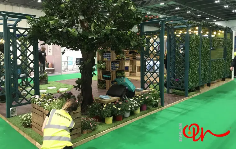 غرفه ای جذاب با درخت و گلدانهای متنوع در نمایشگاه