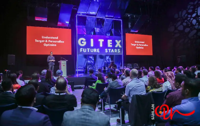 غرفه نمایشگاهی مملو از جمعیت و فردی در حال ارائه مطالب در نمایشگاه جیتکس دبی