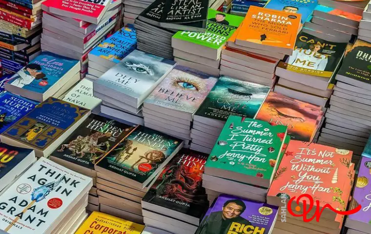 کتابهای مختلف چیده شده در کنار یکدیگر در غرفه نمایشگاه کتاب